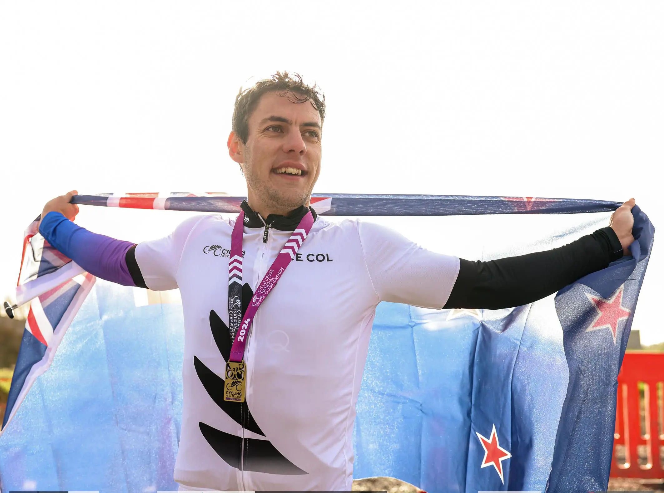 Craig Oliver celebrating at the Cyclocross National Championships with the New Zealand flag